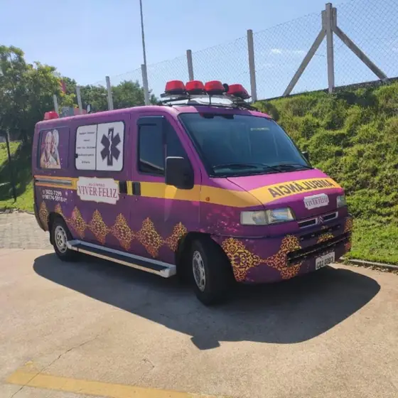 Ambulância roxa e dourada com o logotipo Viver Feliz