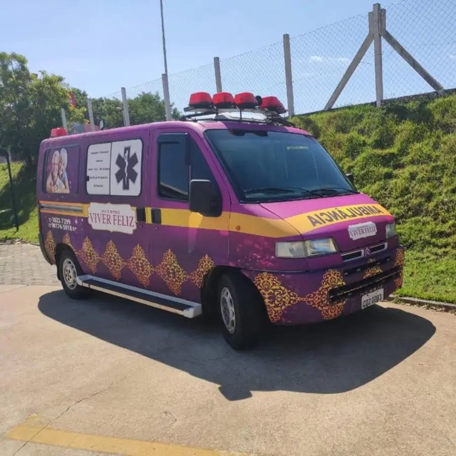 Ambulância roxa e dourada com o logotipo Viver Feliz, estacionada